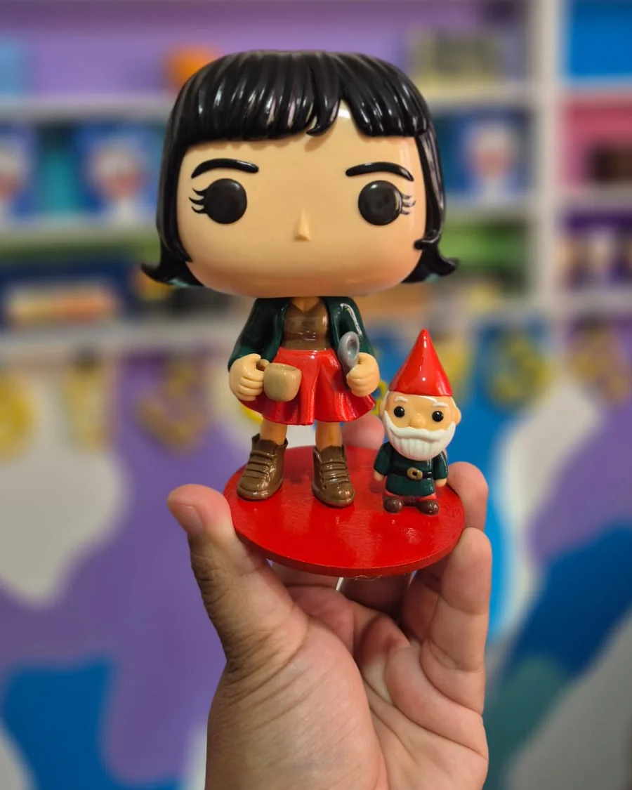 Pop de personagem: figura de casaco verde e saia vermelha com um gnomo de jardim ao lado, feita à mão