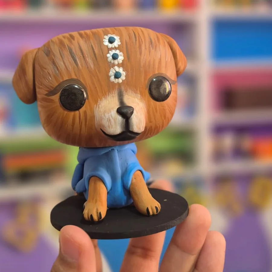 Pop personalizado de uma cachorrinha caramelo de moletom azul, com presilhas de margarida na cabeça