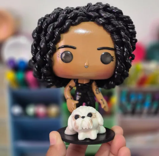 Pop personalizado de uma mulher de cabelo cacheado preto, de roupa preta, com seu cachorro branco na mesma base
